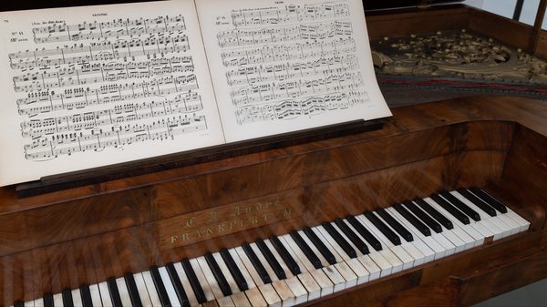 Namensbrett „C. A. André Frankfurt a/M.“, auf dem Pult die Arie der Königin der Nacht zu vier Händen