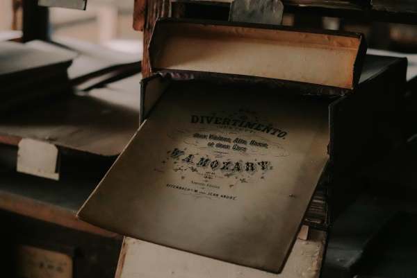Titelblatt eines Divertimentos von W. A. Mozart aus dem Verlag Jean André in Offenbach, halb aus einem Kasten gezogen