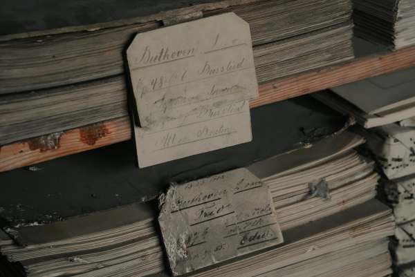 Handschriftliche Schildchen an Notenstapeln, oben ein Etikett zu Beethoven